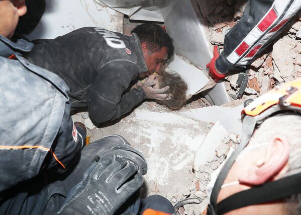 Турецкие спасатели вытаскивают ребенка из под обломков после землетрясения в Измире - Sputnik Қазақстан