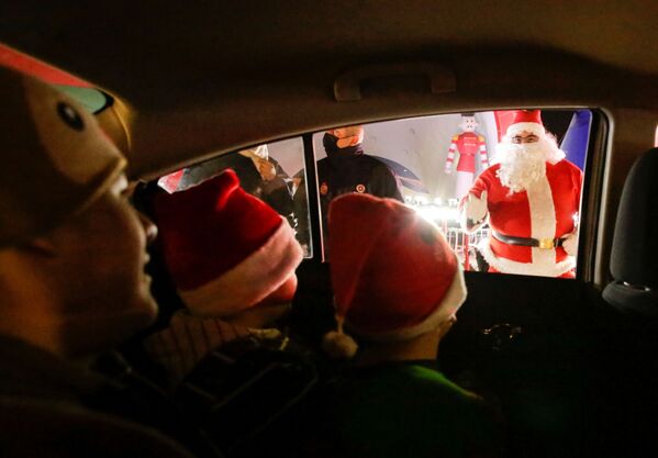Балалар Санта-Клаус киіміндегі адамды автомобиль ішінде отырып тамашалауда - Sputnik Қазақстан