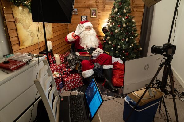 Мужчина в костюме Санта-Клауса во время разговора с семьей по Zoom в Лондоне - Sputnik Казахстан