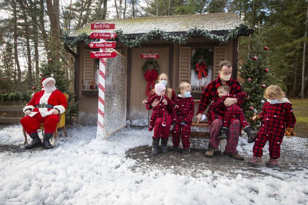 Семья в рождественских нарядах позирует для фотографии с Санта-Клаусом в Кингстоне, Канада  - Sputnik Казахстан