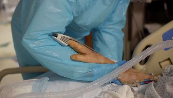 Медик держит за руку пациента в палате интенсивной терапии в больнице с коронавирусом  - Sputnik Қазақстан
