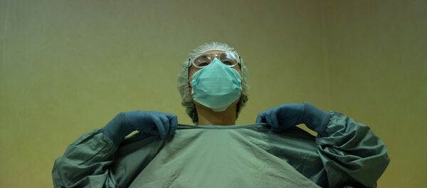 Врач надевает защитный костюм перед началом дежурства в больнице с коронавирусом Врач надевает защитный костюм перед началом дежурства в больнице с коронавирусом - Sputnik Казахстан