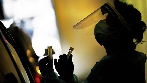 Медик в защитной маске и лицевом экране держит пробирки с пробами для анализа на коронавирус  - Sputnik Казахстан