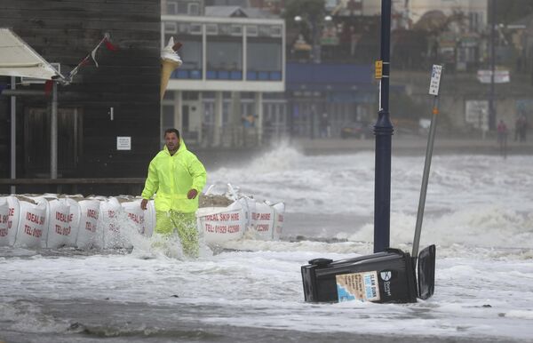 Мужчина на затопленной набережной города Суонедж, Великобритания  - Sputnik Қазақстан