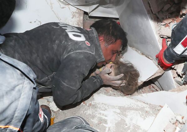 Турецкие спасатели вытаскивают ребенка из под обломков после землетрясения в Измире - Sputnik Казахстан