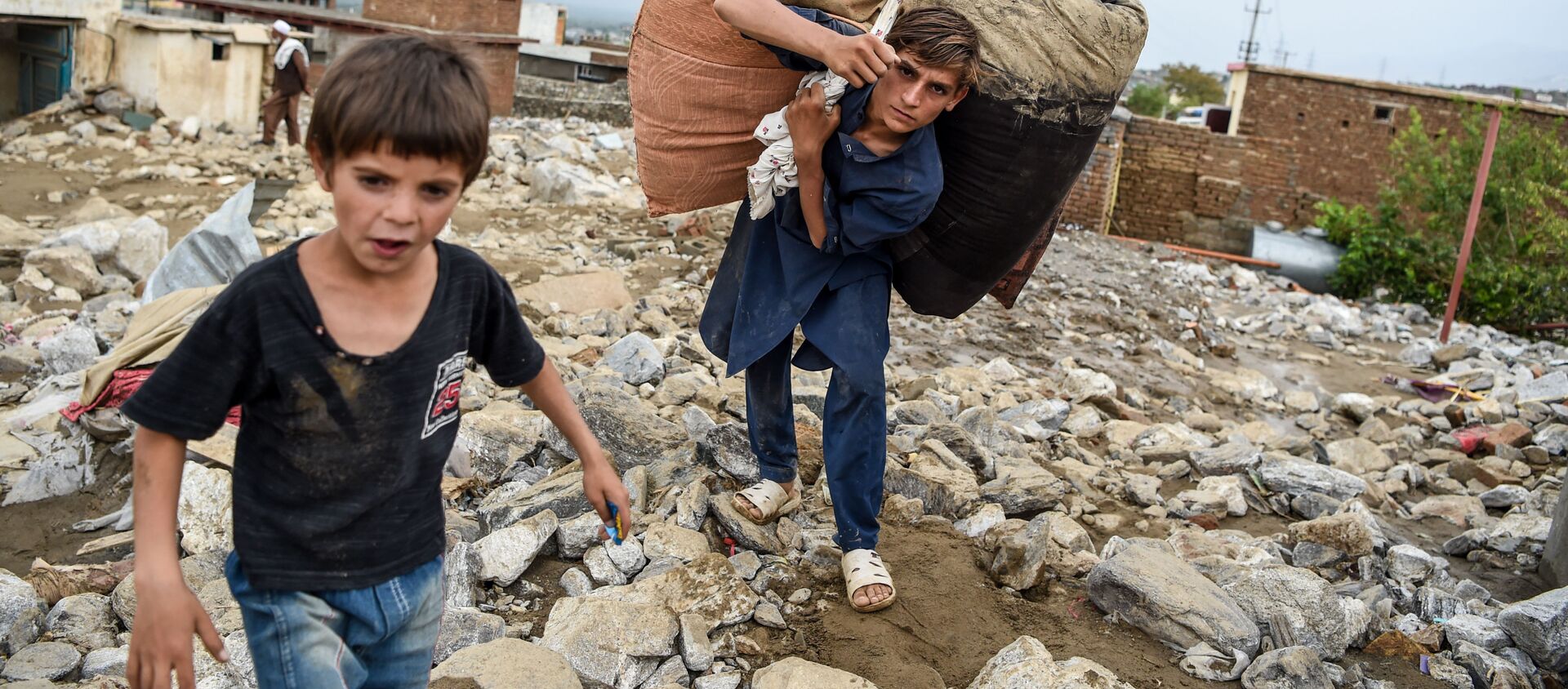 Молодые люди спасают остатки вещей из развалин домов после внезапного наводнения в Чарикаре, провинция Парван, Афганистан - Sputnik Қазақстан, 1920, 28.04.2021