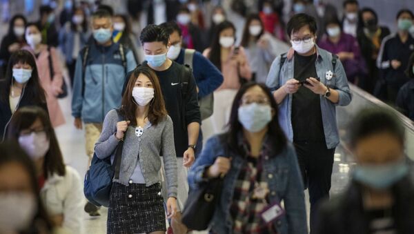 Жители пригородной зоны в медицинских масках на переходе одной из станций метро в Гонконге - Sputnik Казахстан