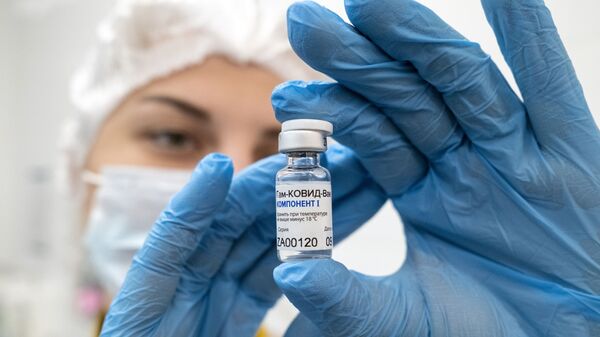 Медработник демонстрирует компонент 1 вакцины от коронавируса Спутник V в прививочном пункте - Sputnik Казахстан