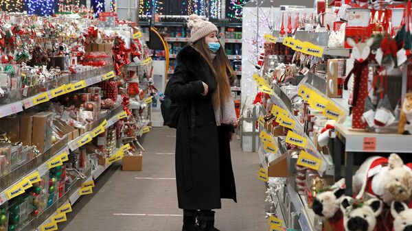 Девушка выбирает елочные игрушки в магазине, архивное фото - Sputnik Қазақстан