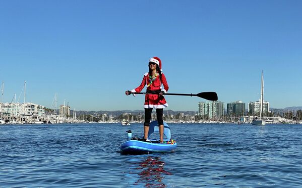 Девушка в костюме Санта-Клауса на SUP-серфе в Лос-Анджелесе, Калифорния - Sputnik Казахстан
