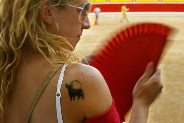 Женщина с татуировкой быка на плече во время корриды на ярмарке Сан-Фермин, Испания - Sputnik Казахстан