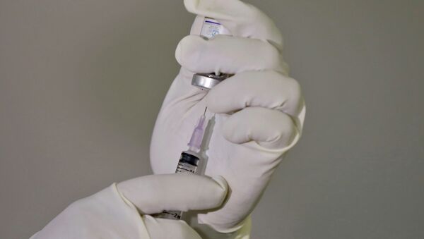 Медик набирает в шприц вакцину от коронавируса - Sputnik Казахстан