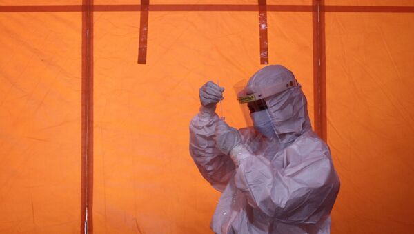 Медик держит в руках пробирку с ПЦР-тестом на коронавирус  - Sputnik Казахстан