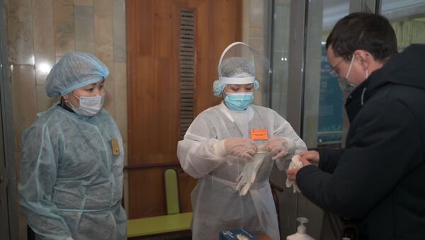 На входе в избирательный участок голосующим предлагают надеть перчатки - Sputnik Казахстан