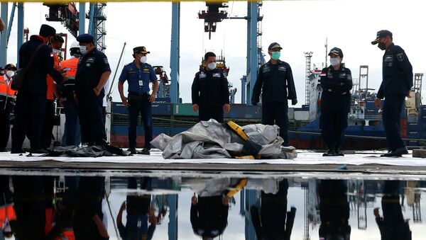 Индонезийские спасатели несут то, что предположительно является останками самолета Sriwijaya Air, следовавшего рейсом SJ182, который упал в море в порту международного контейнерного терминала Джакарты в Джакарте - Sputnik Казахстан
