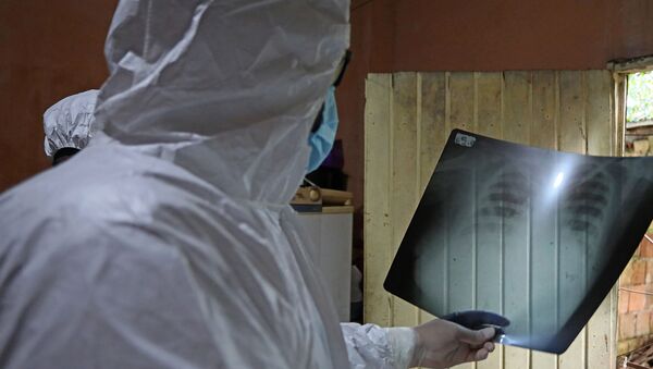 Врач в защитном костюме рассматривает рентгеновский снимок пациента в больнице с коронавирусом  - Sputnik Қазақстан