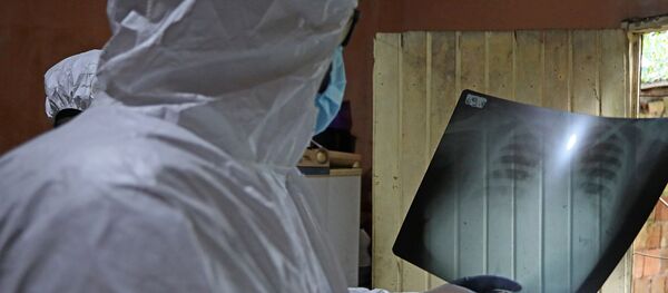 Врач в защитном костюме рассматривает рентгеновский снимок пациента в больнице с коронавирусом Врач в защитном костюме рассматривает рентгеновский снимок пациента в больнице с коронавирусом - Sputnik Казахстан