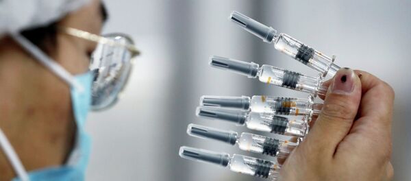 Медик держит несколько шприцев с вакциной от коронавируса  - Sputnik Казахстан