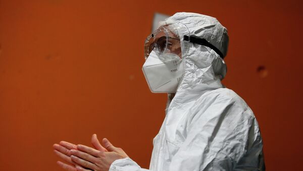 Медик в защитном костюме в больнице с коронавирусом - Sputnik Казахстан