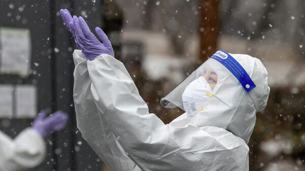 Медик в защитном костюме ловит снежинки на улице в перерыве смены в больнице с коронавирусом - Sputnik Казахстан