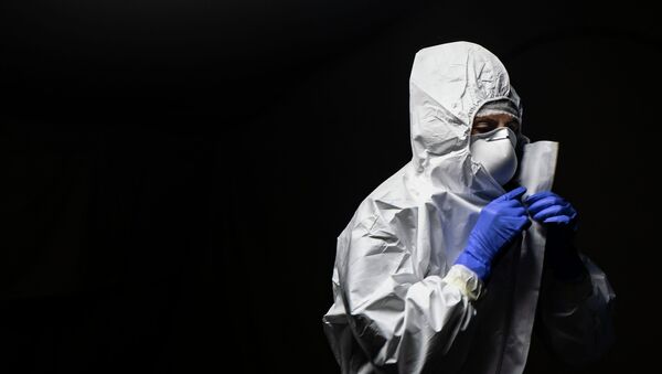 Медик снимает защитный костюм после смены в больнице с коронавирусом  - Sputnik Қазақстан