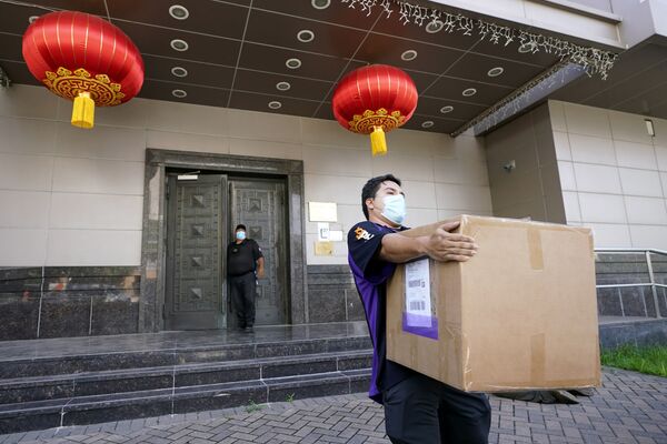 Сотрудник FedEx забирает ящик из китайского консульства в Хьюстоне - Sputnik Казахстан