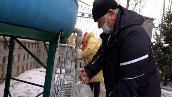 Люди набирают освященную в Крещение воду из емкостей у церкви  - Sputnik Казахстан
