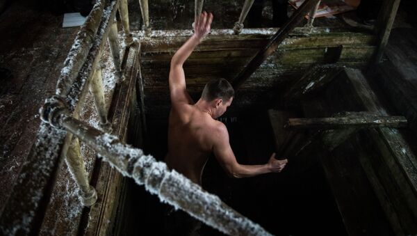 Мужчина окунается в купель во время крещенских купаний  - Sputnik Казахстан
