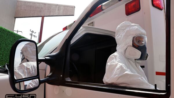Водитель скорой помощи в защитном костюме стоит возле машины  - Sputnik Қазақстан