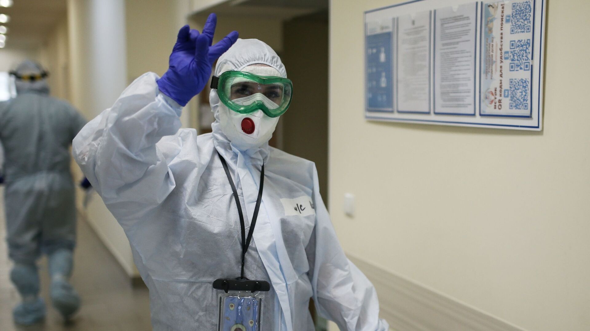 Врач в защитном костюме идет по коридору больницы с коронавирусом - Sputnik Казахстан, 1920, 27.03.2022