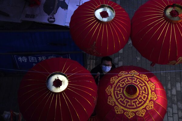 Мужчина вешает фонари к празднованию Лунного Нового года в Ухане, Китай - Sputnik Казахстан