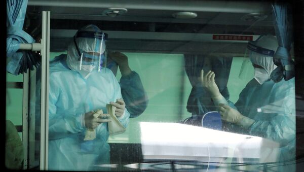 Медики надевают защитные костюмы перед началом работы  в больнице коронавирусом  - Sputnik Казахстан