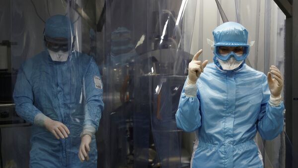 Медики в защитных костюмах проходят через дезинфекционный тоннель в лаборатории по созданию вакцины от коронавируса  - Sputnik Казахстан