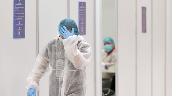 Врач в защитном костюме выходит после смены в больнице с коронавирусом  - Sputnik Казахстан