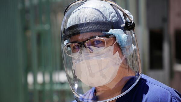 Медик в защитном костюме у больницы с коронавирусом  - Sputnik Казахстан