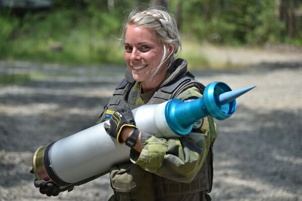 Женщина-военнослужащий армии Швеции несет снаряд во время танковых испытаний Strong Europe - Sputnik Казахстан
