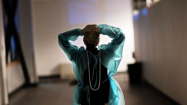 Медсестра в защитном костюме идет по коридору больницы с коронавирусом  - Sputnik Казахстан