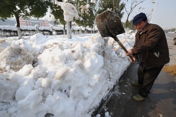 Китайский рабочий чистит улицы от сильного снегопада в Китае, 2008 год  - Sputnik Казахстан