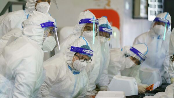 Медики в защитных костюмах проводят летучку перед началом смены  - Sputnik Казахстан