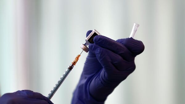 Медик в перчатках набирает вакцину в шприц  - Sputnik Казахстан