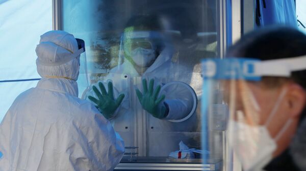 Медики в защитных костюмах готовятся проводить ПЦР-тесты на коронавирус в экспресс-лаборатории  - Sputnik Казахстан