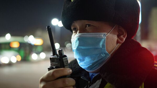 Патрульный полицейский в защитной маске говорит по рации - Sputnik Казахстан