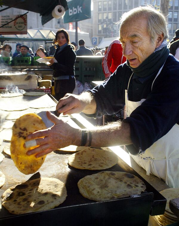 Мужчина готовит традиционный баскские блины на рынке в Бильбао - Sputnik Казахстан