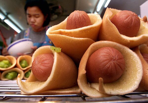 Девушка готовит мини хотдоги из блинов и сосисок в Бангкоке  - Sputnik Казахстан