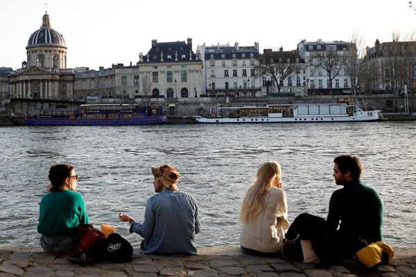 Люди наслаждаются солнечной и теплой погодой на берегу реки Сены в Париже - Sputnik Казахстан