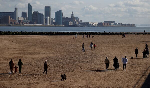 Люди гуляют по пляжу в Британии - Sputnik Казахстан