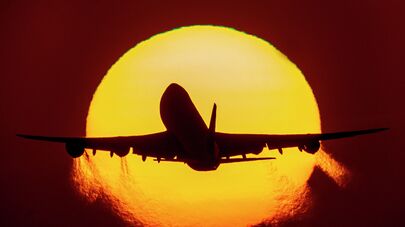 Самолет взлетает на фоне заката 