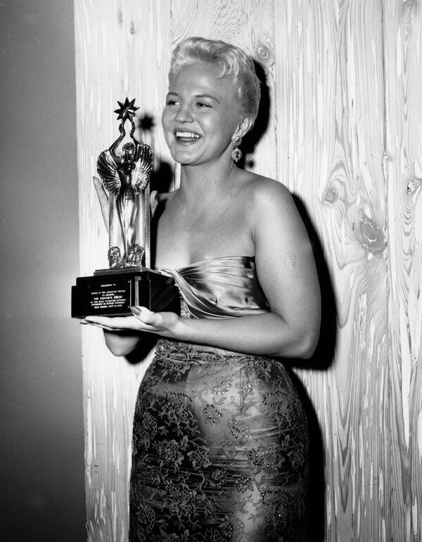 Певица Пегги Ли держит в руках статуэтку &quot;Приз зрительских симпатий&quot; в Голливуде, Калифорния, 6 декабря 1955 года. - Sputnik Казахстан