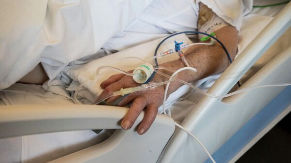 Рука пациента с капельницами в палате интенсивной терапии в больнице с коронавирусом - Sputnik Казахстан