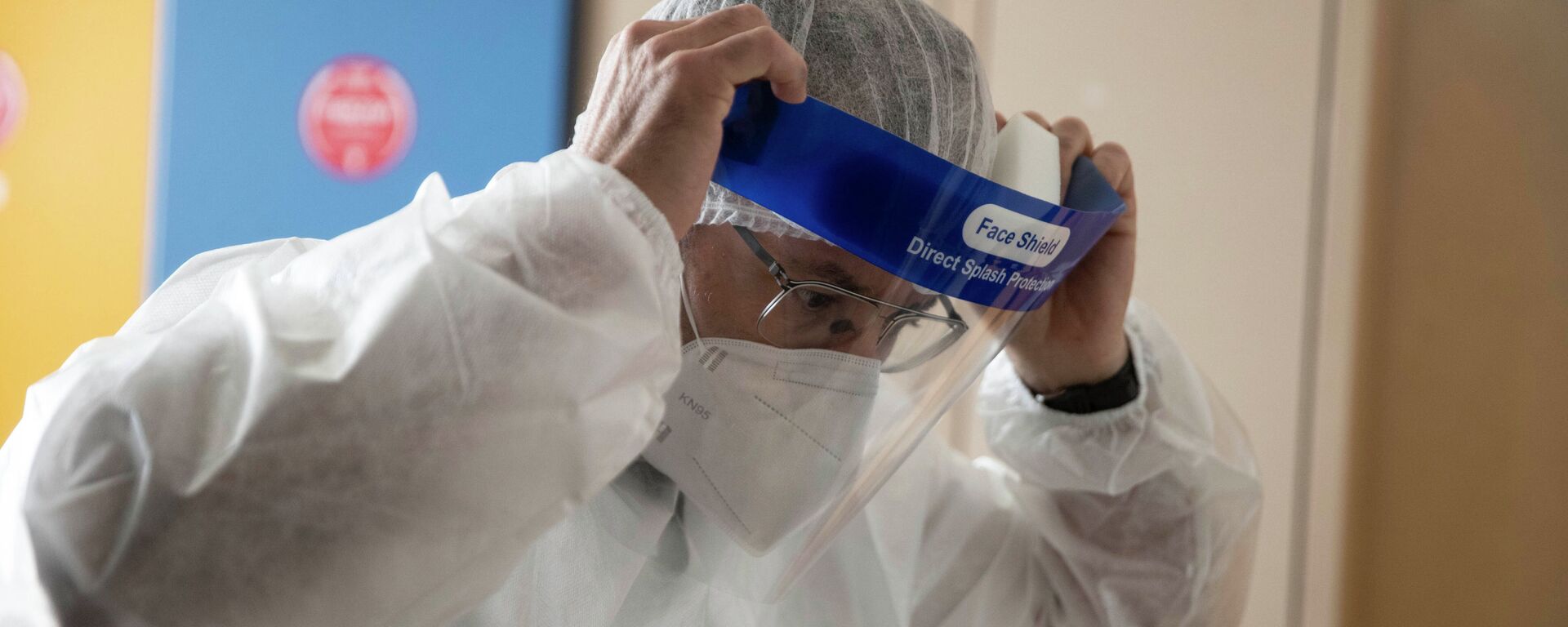 Врач поправляет защитный лицевой щиток перед началом смены в больнице с коронавирусом  - Sputnik Казахстан, 1920, 31.03.2021